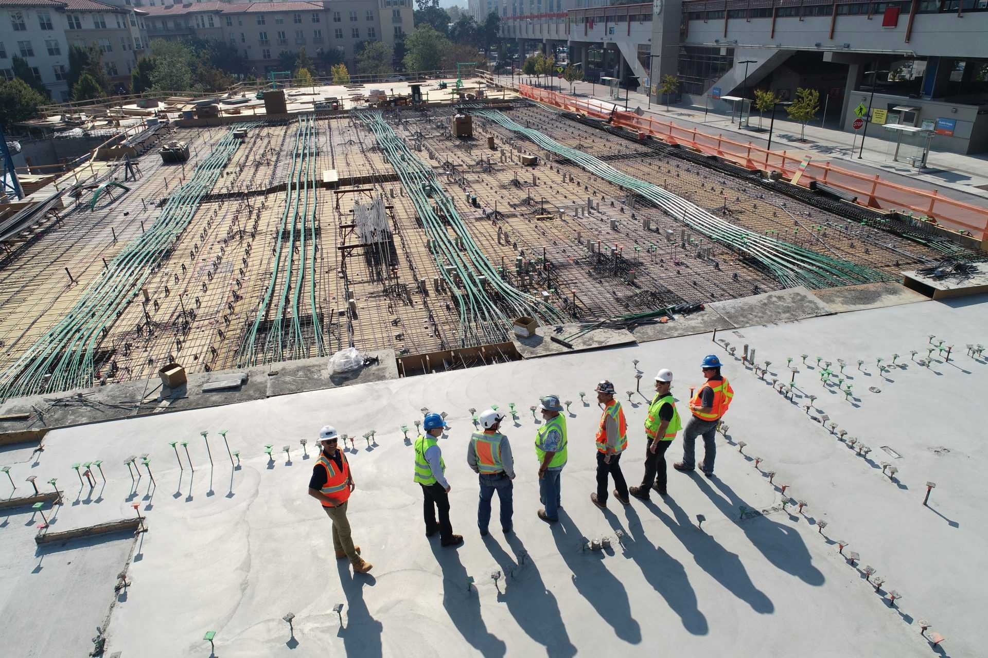 Siete trabajadores de la construcción de pie sobre un campo blanco